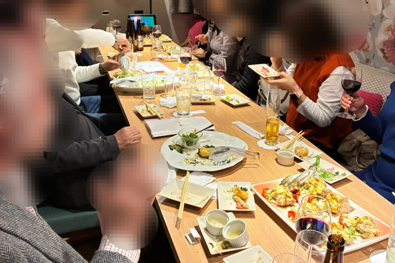 新宿の個室和食店で60代・70代の男女が笑顔で乾杯し、茶飲み友達づくりの食事会を楽しんでいる様子